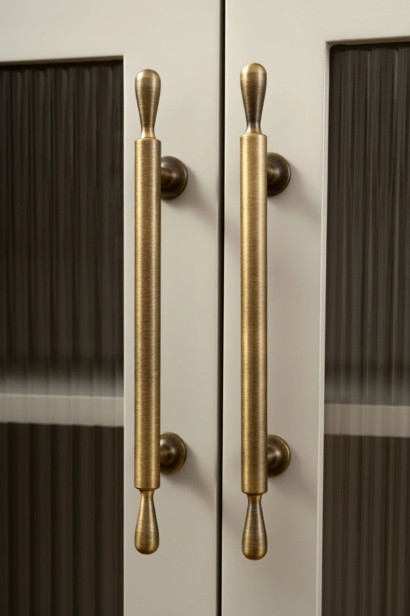 Brass door handles on a glass door with 'Santaya' branding.