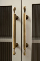 Brass door handles on a glass door with 'Santaya' branding.