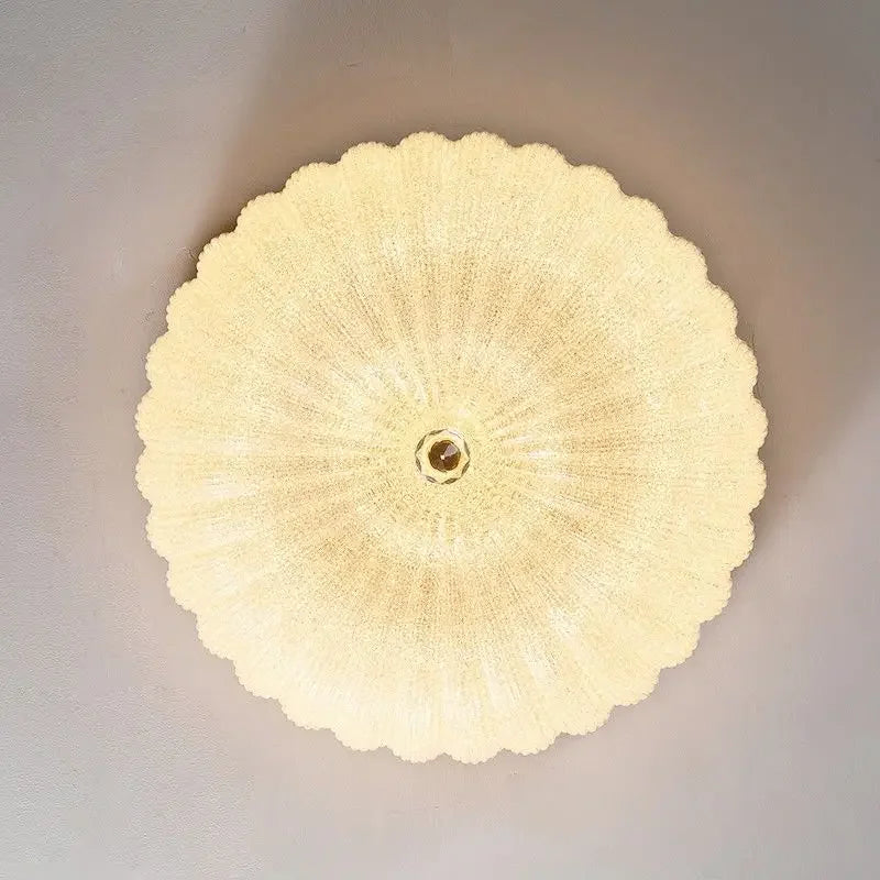Round scalloped acrylic diffuser for a flush-mount LED ceiling light with brass center