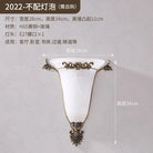 Gold wall sconce with frosted glass shade and vintage scroll metal mount